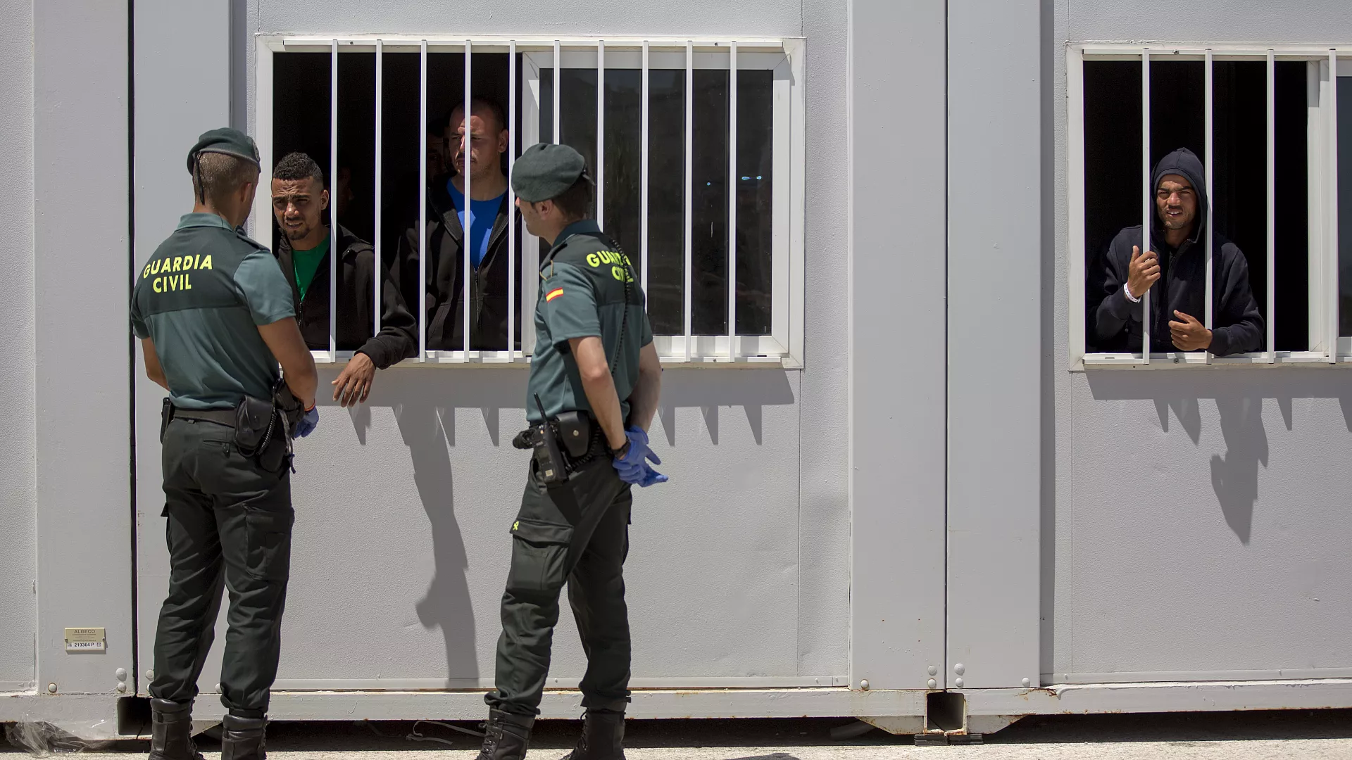 Agentes de la Guardia Civil habla con migrantes confinados en un centro de emergencia improvisado en el puerto de Barbate, sur de España, 27 de junio de 2018 - Derechos de autor Emilio Morenatti/Copyright 2018 The AP. All rights reserved.