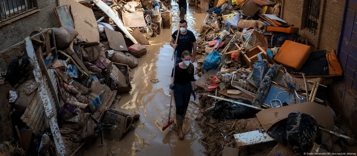 España: servicios de emergencia y voluntarios tratan de limpiar una calle devastada por las inundaciones, en Paiporta, Valencia. Foio: Emilio Morenatti/AP/dpa/picture alliance