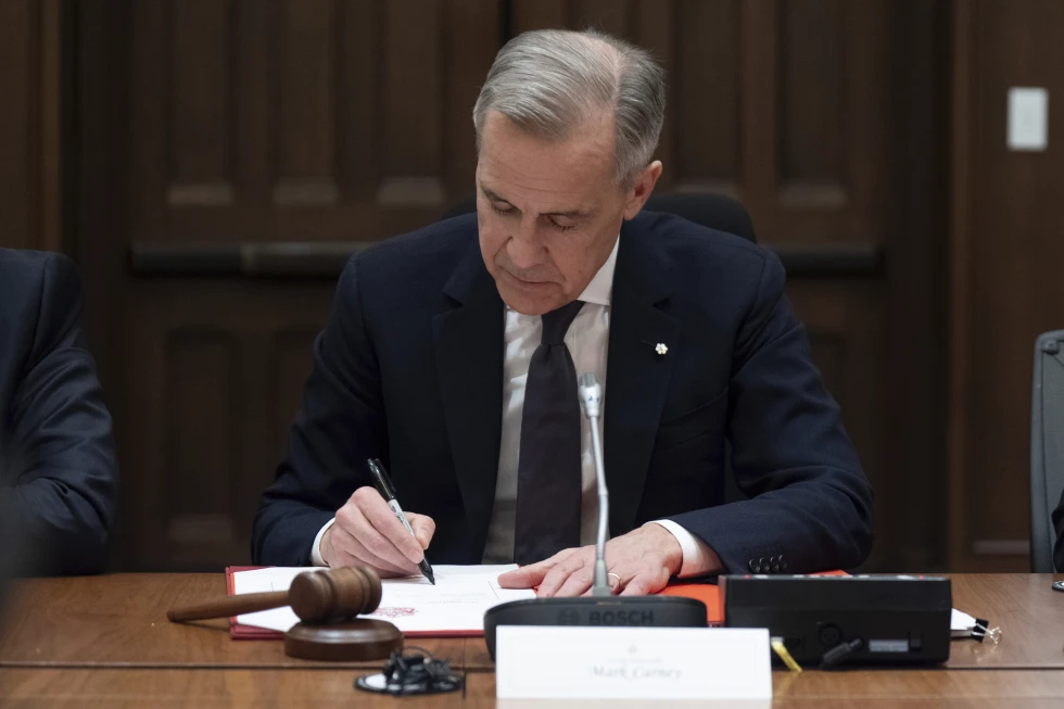 El primer ministro de Canadá, Mark Carney, firma un documento durante una reunión del gabinete en Parliament Hill, el viernes 14 de marzo de 2025 en Ottawa. Foto: Adrian Wyld/The Canadian Press via AP
