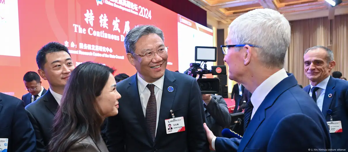 El ministro de Comercio chino, Wang Wentao (centro) saluda en Pekín al delegado consejero de Apple, Tim Cook (derecha). Imagen de archivo: Li Xin/Xinhua/picture alliance