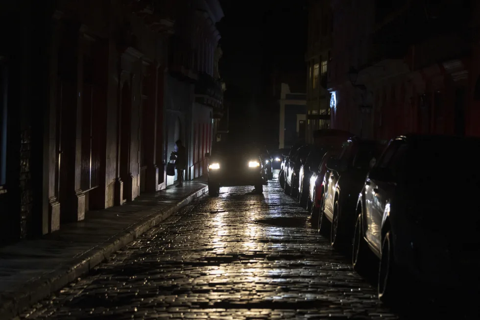 Los faros de un auto iluminan las calles empedradas del Viejo San Juan, Puerto Rico, durante un apagón en la isla, el 16 de abril de 2025. (AP Foto/Alejandro Granadillo)