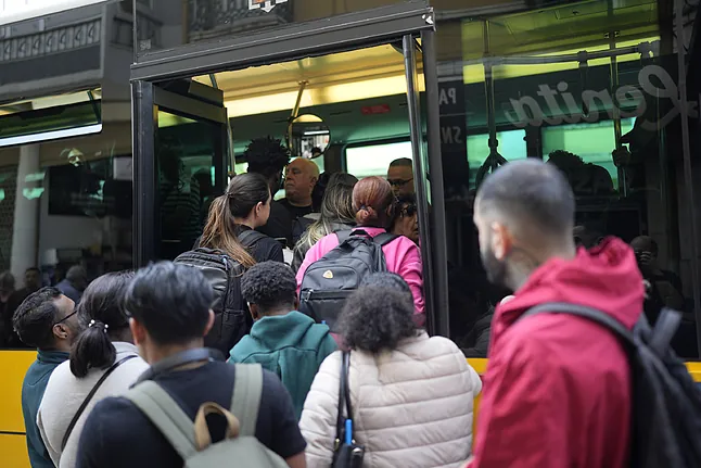 Personas intentan abordar un autobús después que el metro dejó de operar debido a un apagón, en Lisboa. Foto: Armando Franca / AP