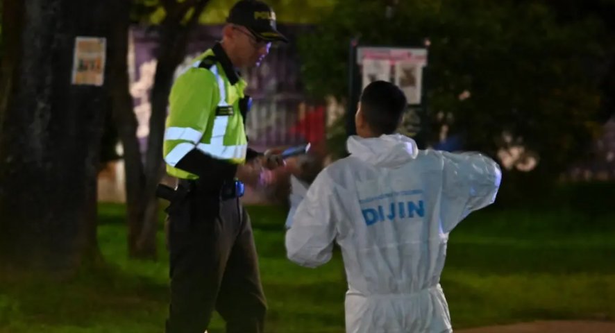 Un perito forense conversa con un policía mientras trabaja en la escena del crimen donde el senador Miguel Uribe Turbay fue herido de bala en el barrio Modelia de Bogotá el 7 de junio de 2025. Foto: AFP, Bluradio