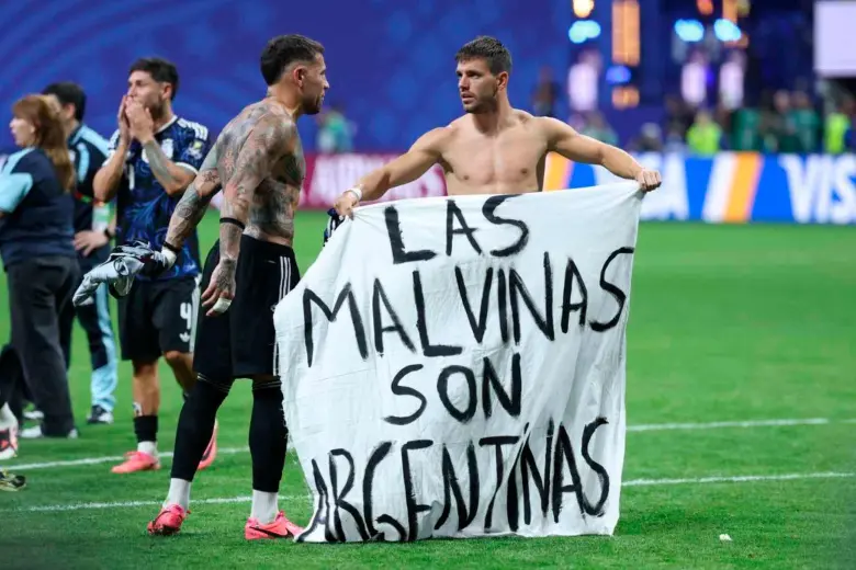 Los jugadores Giovani Lo Celso, Lisandro Martínez y Nicolás Otamendi exhibieron la pancarta en el césped del estadio